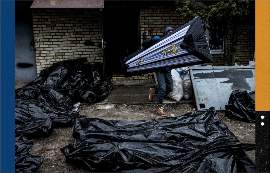 Чоловік несе труну повз мішки з трупами, поки поліція розслідує сотні вбивств у Бучі