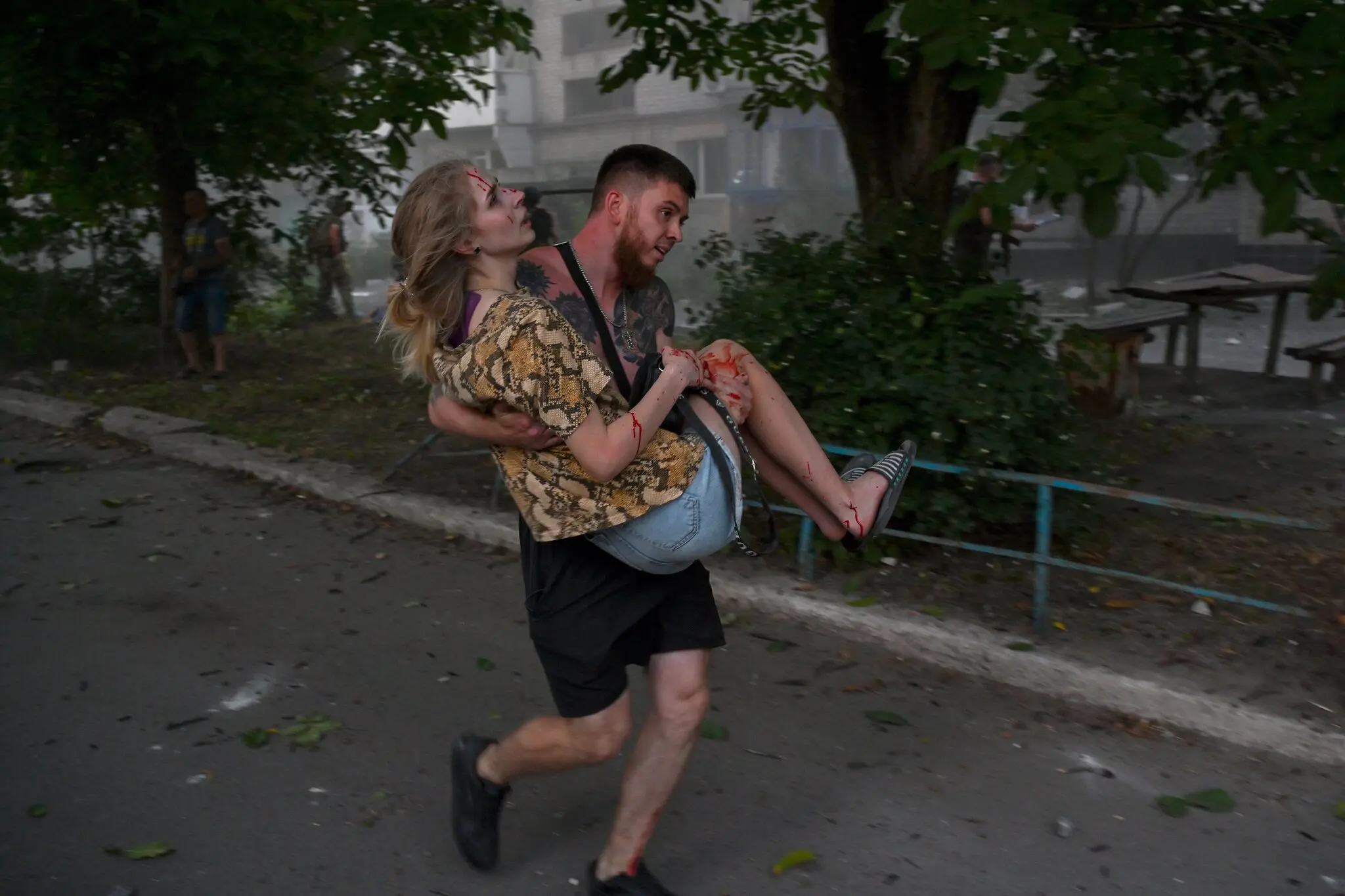 Чоловік несе поранену жінку після російського удару в Покровську, Україна, у понеділок