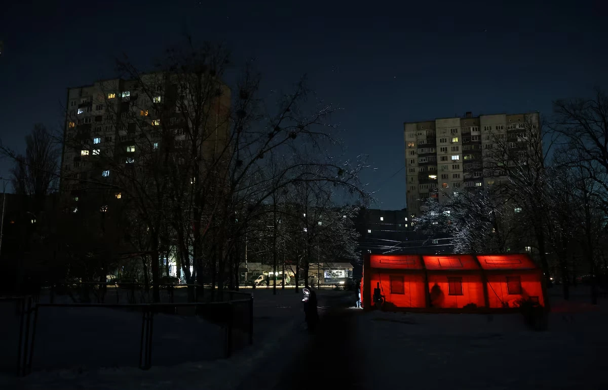 Мешканець стоїть біля наметів урядового пункту гуманітарної допомоги, встановленого поруч із багатоквартирними будинками, де мешканці можуть зігрітися, зарядити свої пристрої, отримати гарячі напої та психологічну підтримку