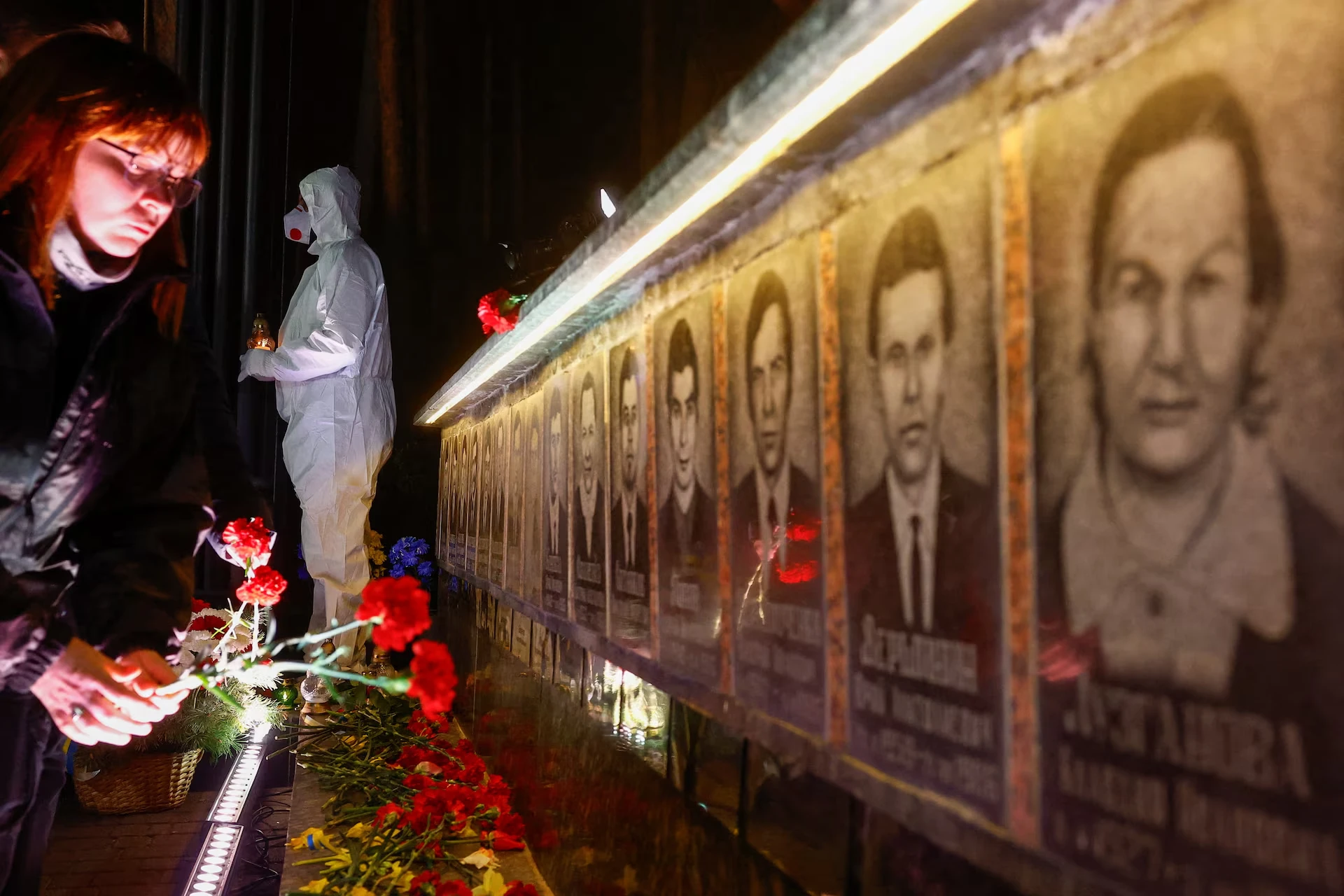 Жінка покладає квіти до меморіалу, присвяченого пожежникам та робітникам, які загинули після Чорнобильської ядерної катастрофи 1986 року, під час нічної поминальної служби з нагоди її 40-ї річниці на тлі нападу Росії на Україну, у Славутичі, Україна, 26 квітня 2026 року